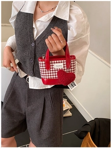 Détail du mini sac seau à carreaux rouges avec breloque cœur et étiquette Helahe
