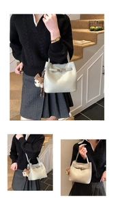 Dettaglio borsa beige con trama a grana e un simpatico ciondolo a forma di orso