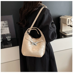 Detail of beige bucket bag showing vintage cracked texture and silver metal clasp