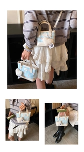 Détail du sac seau en toile à carreaux bleus avec breloque cœur et bandoulière