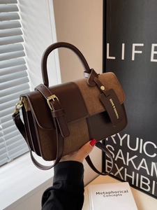 Retro colorblock leather handbag for women featuring top handle and adjustable shoulder strap