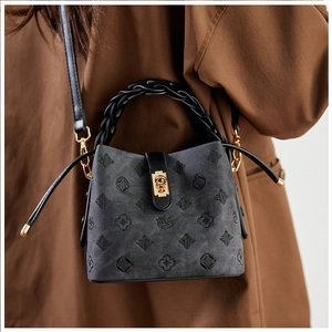 Close-up of retro bucket bag with diamond embroidery and gold metallic lock detail