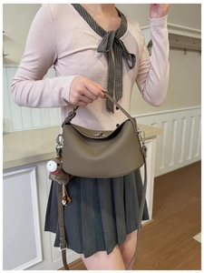 Detail of grey lychee leather handbag featuring iconic top handles and brown horse charm