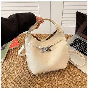 Détail du sac seau crème avec boucle en métal argenté et bandoulière réglable