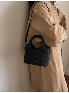 Vue détaillée du cuir noir avec logo argenté et finitions métalliques de haute qualité