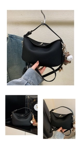 Detail of a black pebbled leather underarm bag with metal clasp and horse charm accessory
