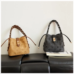 Detailed view of embossed bucket bags in khaki and charcoal with woven handles and metal locks