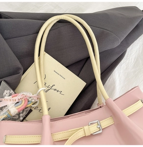 Close-up of pink large capacity tote bag with buckle straps and rainbow charm detail