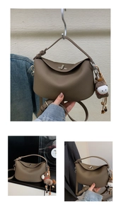 Detail of dark brown lychee leather underarm bag with metal twist lock and horse charm