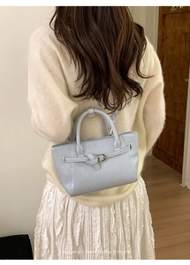 Minimalist light blue PU leather bucket bag with ribbon knot detail shown on model