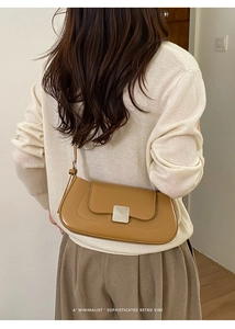 Detail of camel leather shoulder bag featuring vintage silver buckle and decorative stitching