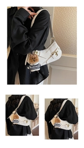 Detail of white saddle bag with gold buckle and a cute brown puppy plush charm