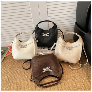 Détail de quatre sacs seaux élégants en cuir avec boucles métalliques et bandoulières