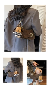Detail of dark brown saddle bag with vintage metal buckle and plush puppy charm