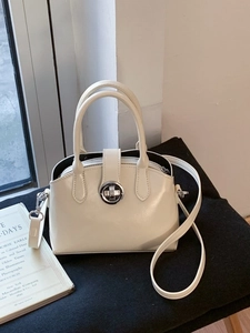 Minimalist cream-white patent leather handbag with silver rotary lock and shoulder strap