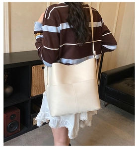 Detailed back view of a large cream-colored bucket bag in textured lychee leather