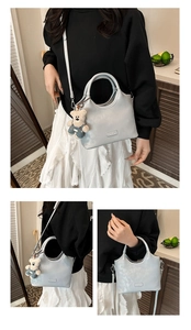 Détail du sac à main argenté métallisé avec breloque ours en peluche et bandoulière