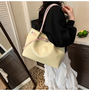 Detail of cream and pink tote bag showing smooth faux leather texture and metallic buckle