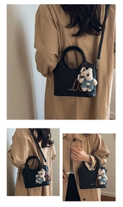 Détails d'un sac à main noir en cuir PU avec pendentif ours et bandoulière réglable