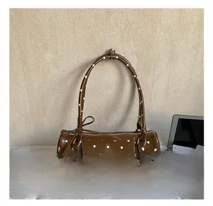 Détails du sac cylindrique marron à pois avec pendentif en forme de cœur doré