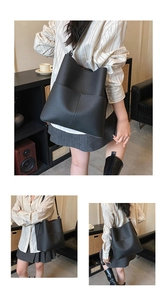 Close-up of black lychee grain bucket bag showing large capacity pocket and texture
