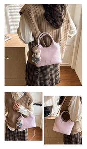 Détail du sac à main rose en similicuir avec bandoulière et breloque ours en peluche