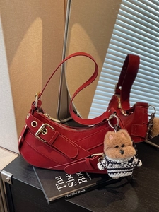 Retro red half-moon shoulder bag in faux leather with buckled straps and dog charm