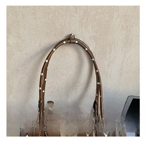 Gros plan du sac à main marron à pois avec poignées renforcées et boucles en métal argenté