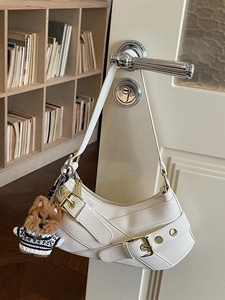 White crescent underarm bag with gold buckles and a cute brown puppy plush charm
