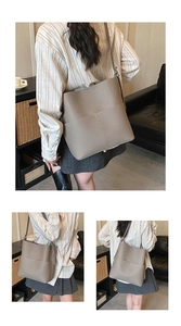 Detail view of elephant gray bucket bag featuring litchi texture leather and adjustable strap