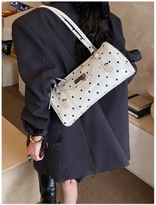 Vue détaillée d'un sac baguette vintage à pois avec des finitions en métal argenté
