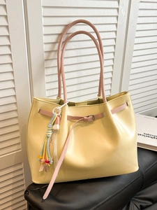 Large yellow tote bag in soft leather with pink handles and colorful LOVE tassels