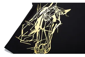 Détail d'un t-shirt noir avec imprimé tête de cheval géométrique doré et logo