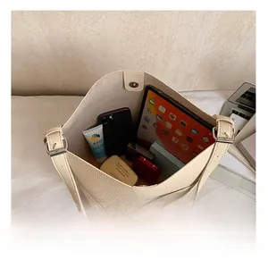 Interior view showing the large capacity of the beige leather bucket bag for tablet and phone