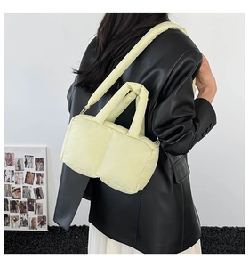Quilted puffer tote bag in cream yellow shown worn with a black leather jacket