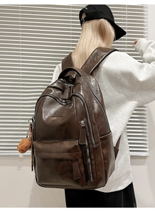 Side view of large dark brown retro PU leather backpack with cute plush bear charm