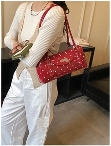 Detail of red polka dot cylinder bag with heart buckle in a vintage French style