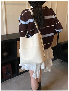 Detailed view of beige faux leather tote bag showing large capacity and lychee texture