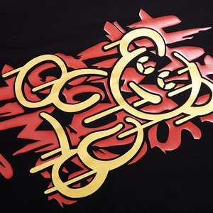 Close-up of black cotton T-shirt featuring high-density red and gold graffiti art print