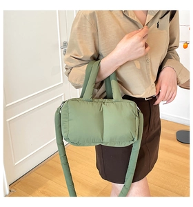 Side view of a soft quilted puffy tote bag in grass green with a matching shoulder strap