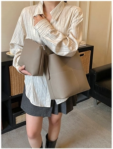 Taupe pebbled leather tote bag and pouch set shown in a stylish home interior setting