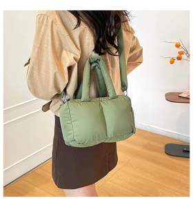 Green quilted tote bag shown from a back view on a model for size and style guide