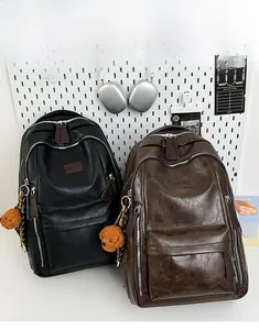 Detail of PU leather backpacks showing smooth texture and twin front zipper pockets