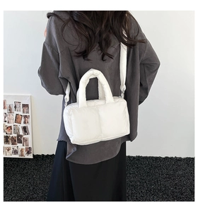 Detailed back view of a white padded tote bag with soft puffer texture and wide strap
