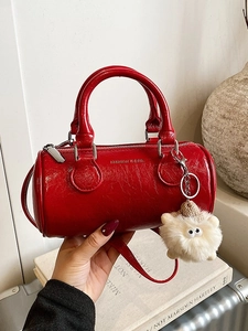 Red cylinder pillow handbag with pleated patent leather and plush monster charm