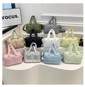 Collection of quilted down tote bags shown in ten various colors on white stairs