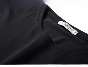 Detail of double-stitched neckline and white size label on a black cotton oversized T-shirt