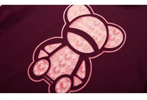 Macro shot of bear print and LIUGEJIA text on burgundy cotton oversized T-shirt