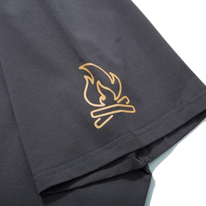Detailaufnahme eines dunkelgrauen T-Shirt-Ärmels mit orangefarbenem Lagerfeuer-Druck
