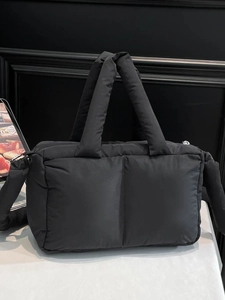 Black quilted puffer tote bag with soft padded handles and crossbody strap for women